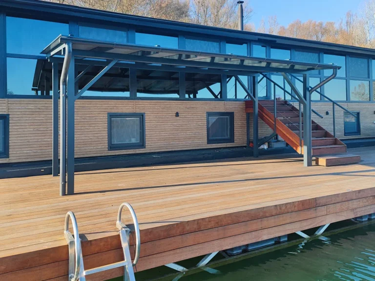 On the newly built aluminum pontoon, we implemented an aluminum terrace canopy, which makes warm summer moments more pleasant and protects from direct sunlight. The pergola is custom-designed and consists of aluminum profiles from which the canopy is welded. It consists of two parts, which are connected by roof jacks, on which the roofing is attached. The roof consists of AluBond aluminum sandwich panels, while the entire structure is in anthracite color, like the existing houseboat.