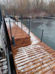 Pre nášho stáleho zákazníka sme rekonštruovali existujúci oceľový pontón, pre pohodlnejšie nastupovanie a vystupovanie z člnov. Rekonštrukcia spočívala z výroby nového pontónu rozmerov 8x2m a jeho napojeniu na existujúci pontón. Na pontóne sa nachádza nájazdová rampa, pomocou ktorej je zabezpečený prístup na zníženú lávku. Pre pristávací pontón s drevenou palubou sme použili plastové plaváky vyplnené polystyrénom.